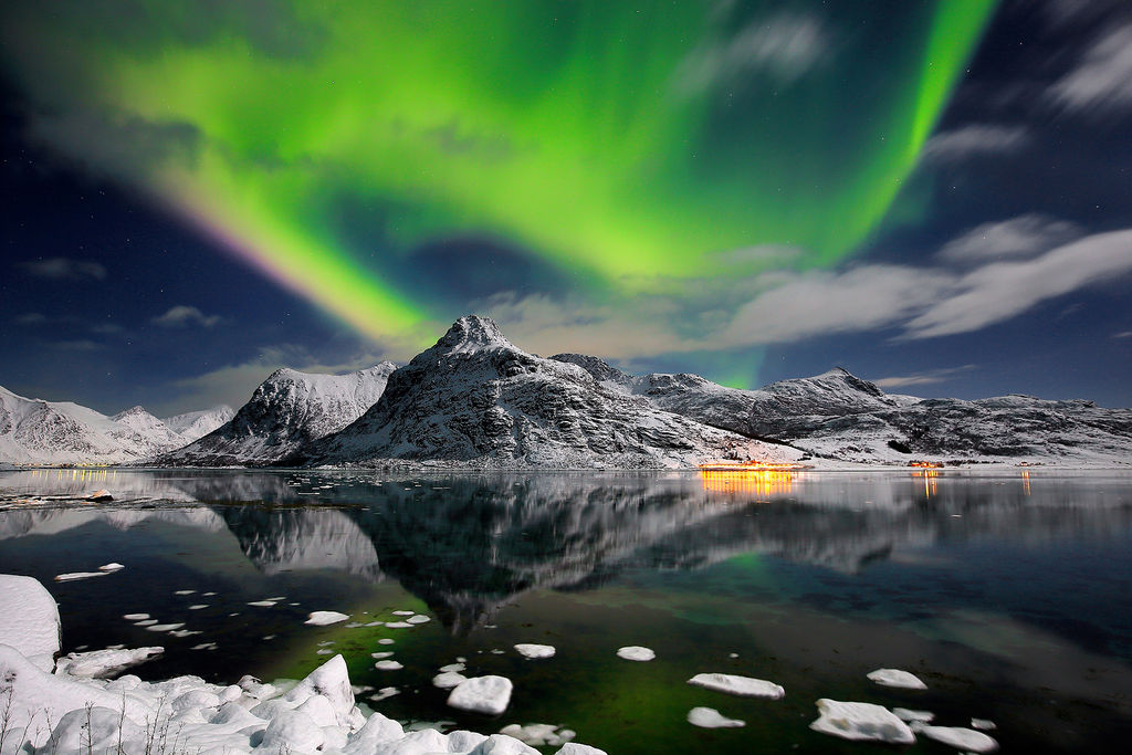 Aurora borealis in Lofoten islands, with snowy mountains reflected in the sea