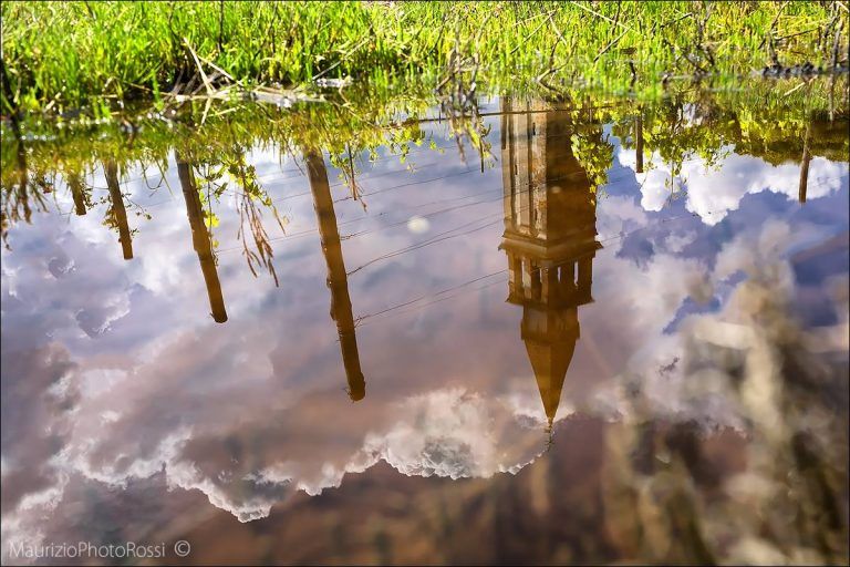 Riflesso nell’acqua tra cielo e campanile: Maurizio Rossi