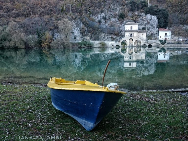 Barca blu e gialla: contrasto cromatico sul paesaggio quieto