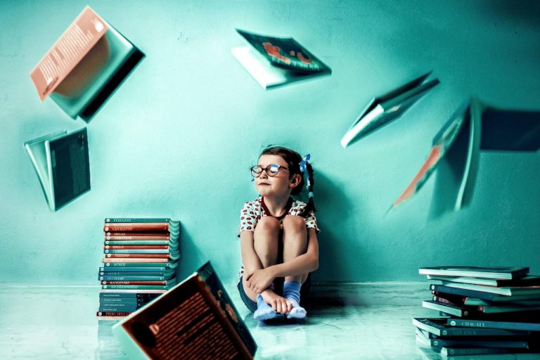 Ritratto di bambina tra libri e ombre sulla parete