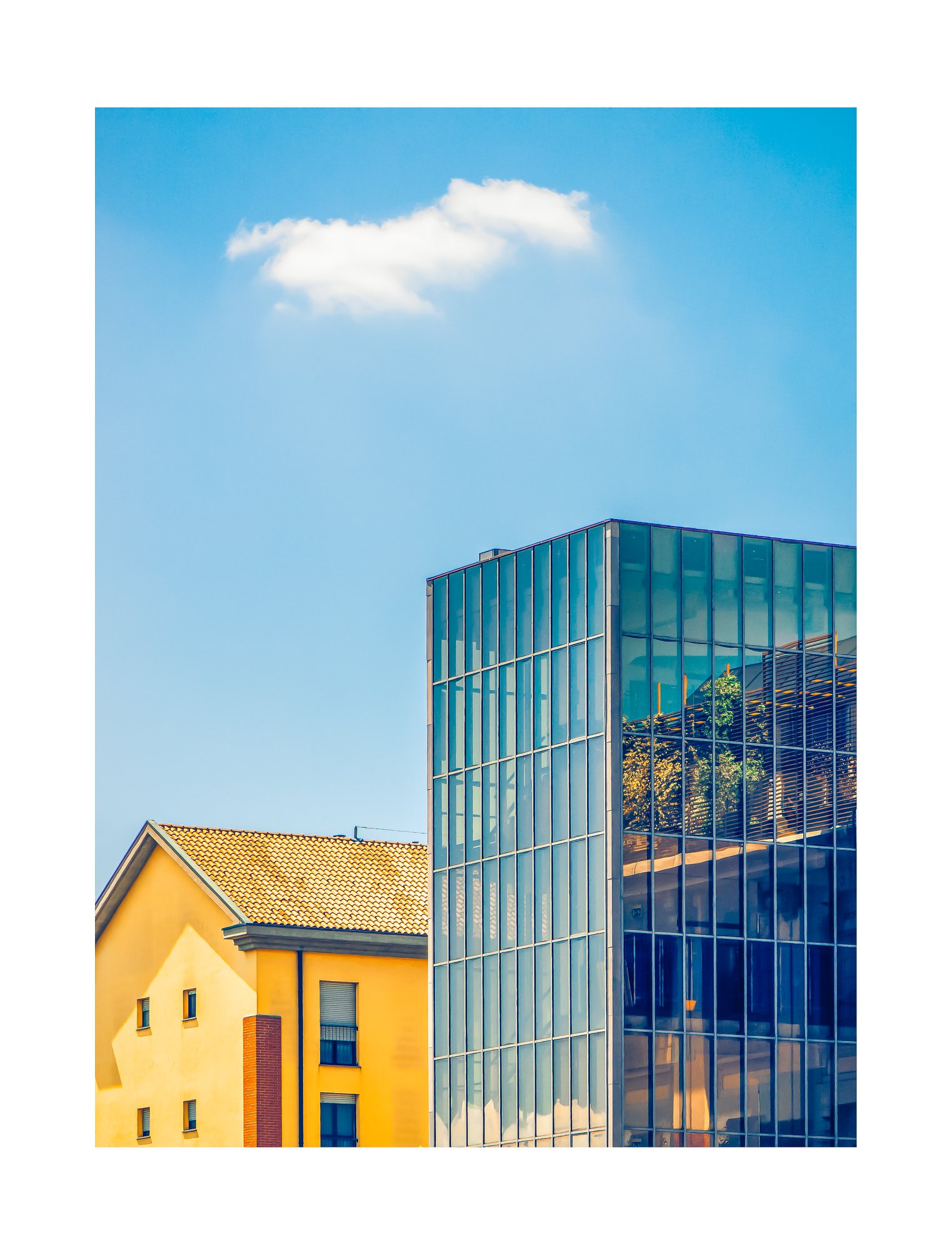 L’ala di vetro contro l’edificio giallo: tensione diagonale e cielo rosso-azzurro