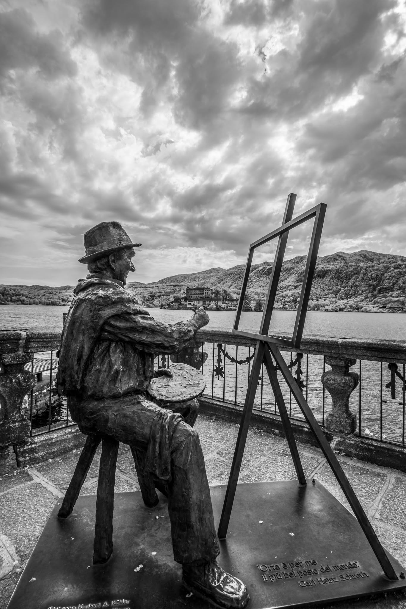 Memoria in bianco e nero: statua e lago in Orta San Giulio con cornice teatrale